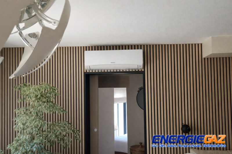 Installation d’une climatisation murale Hitachi intégrée sur panneau décoratif bois. Pose soignée et parfaitement centrée pour un rendu esthétique et moderne – Réalisation ENERGIEGAZ.